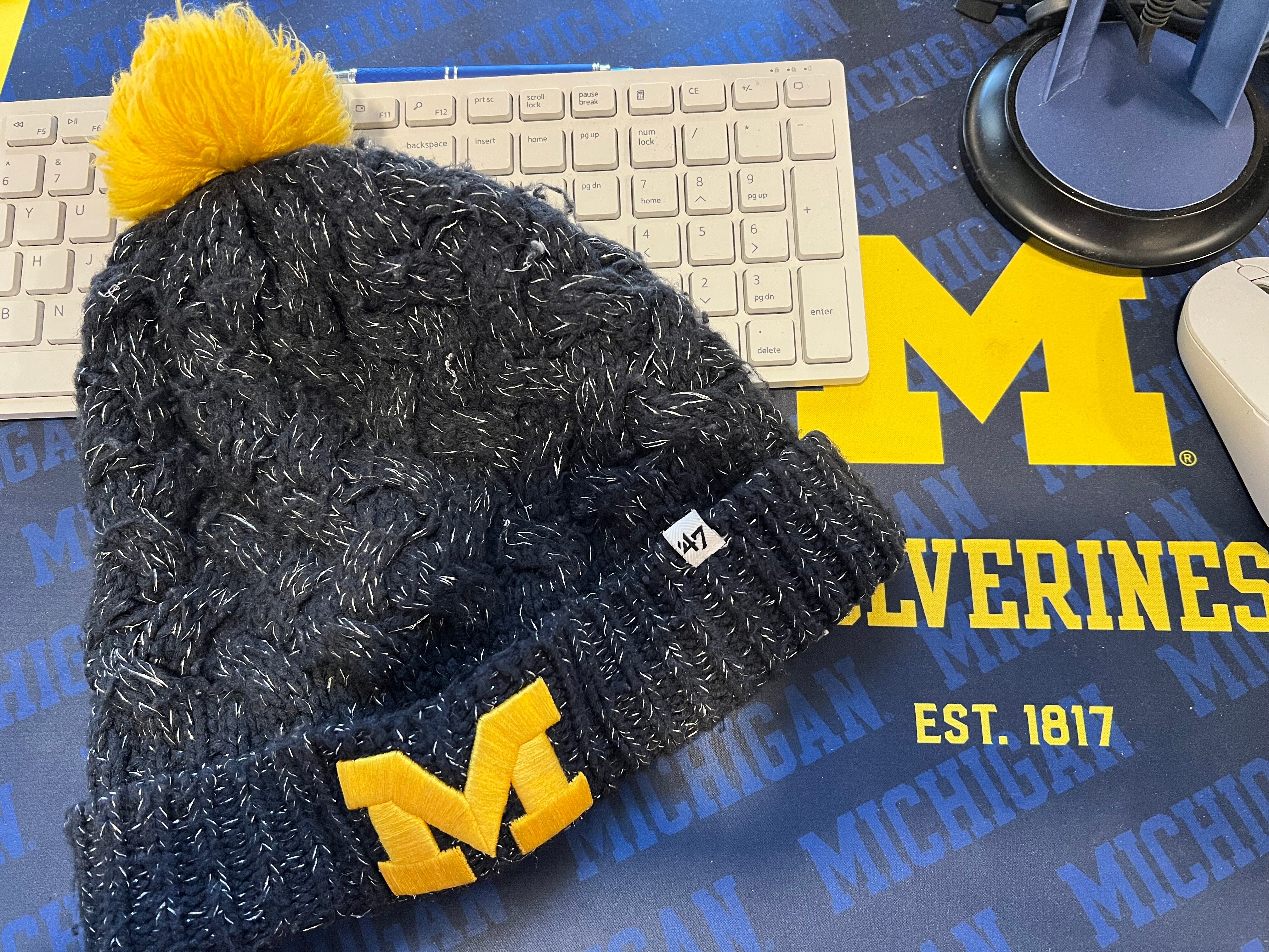 University of Michigan knit cap rests on a Michigan deskpad